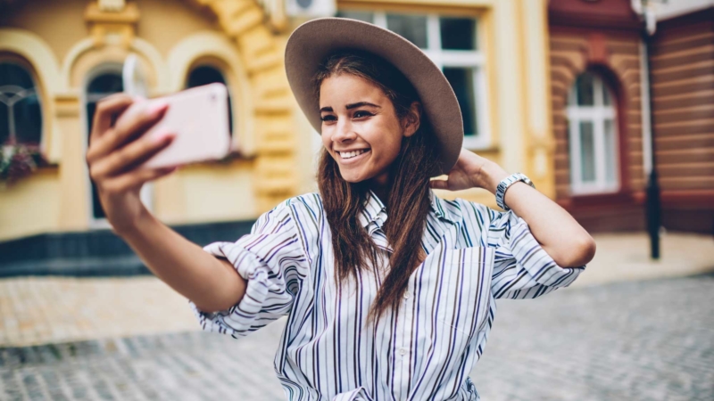 photo of young woman taking a selfie in a foreign city
