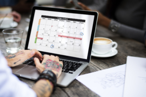 photo of man checking his content calendar on laptop