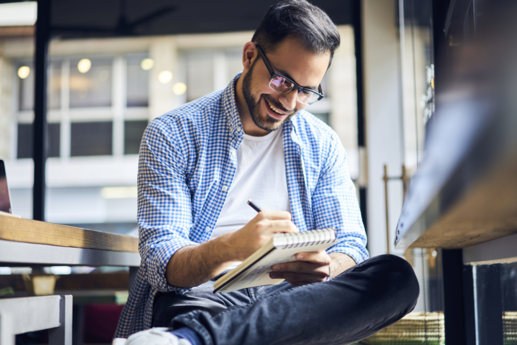 photo of man writing in notebook