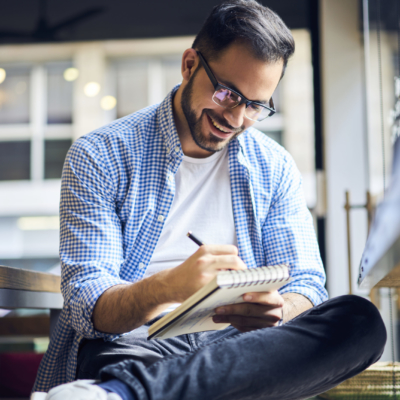 photo of man writing in notebook