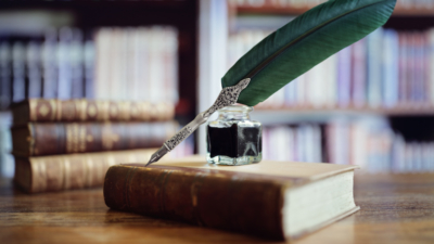 Books and quill pen in library