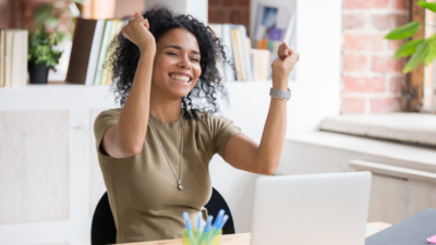 Photo of woman with arms raised in excitement