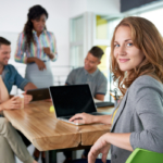 Image of a succesful casual business woman using laptop during meeting