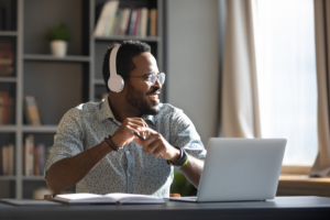 photo of man listening to computer with headphones