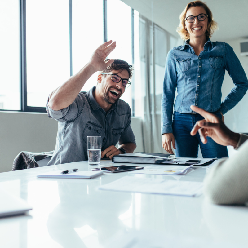 Businessman offering high five to a coworker during a meeting