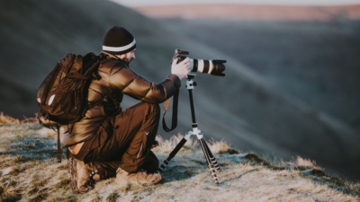 photographer taking landscape photo on mountain