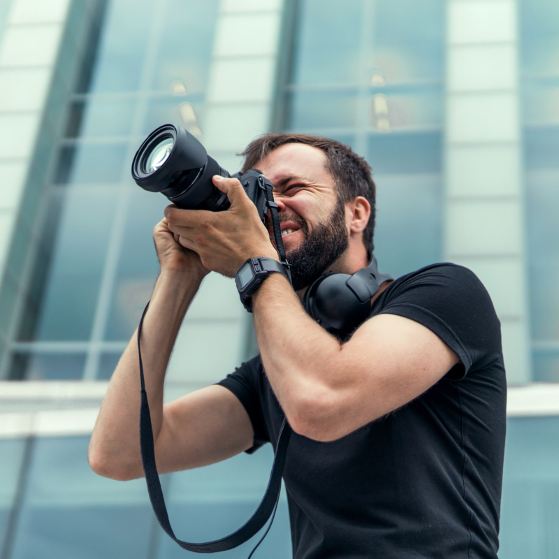 Young male photographer taking pictures of buildings