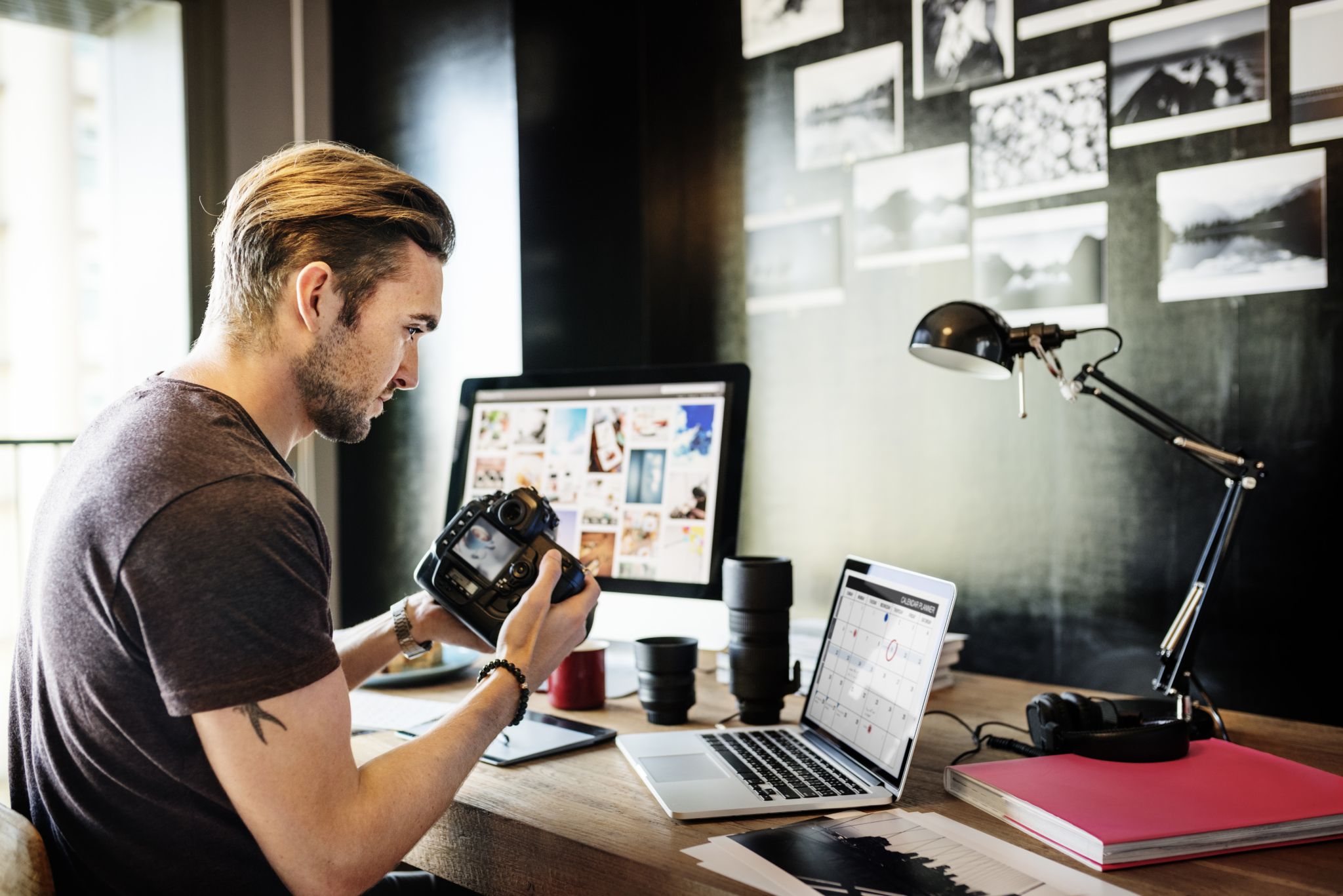Male photographer working at desk on laptop