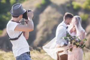 A wedding photographer takes pictures of bride and groom