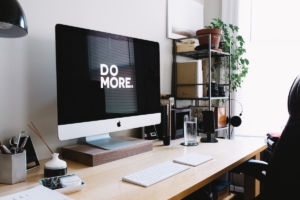 bold typography that says "DO MORE" on a Mac computer