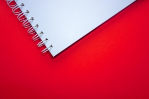 white spiral notebook on red surface; minimal website concept