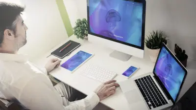 photo of man using two computers to combine websites