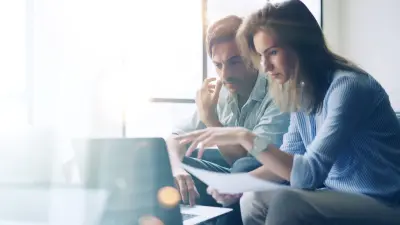 Two people collaborating on laptop