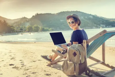 photo of blogger working on beach with laptop