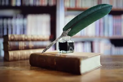 Books and quill pen in library