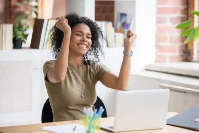 Photo of woman with arms raised in excitement