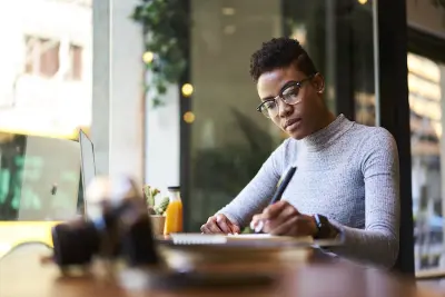 Woman sitting at desk writing in notebook
