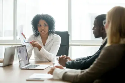 African Businesswoman Showing Good Statistics Report Explaining Deal Advantages During Meeting