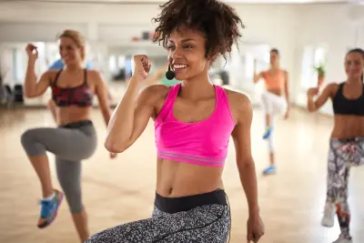 Young female trainer with headset lead group training