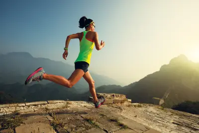 Young woman trail runner running at great wall on the top of mountain