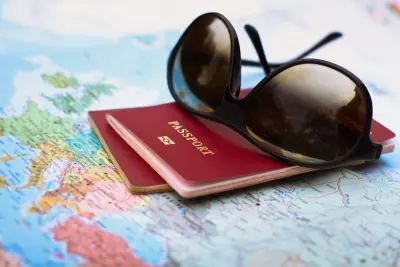 sunglasses and passports stacked on top of an open map; travel concept