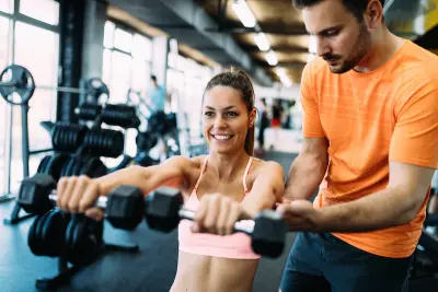 Beautiful woman doing exercises in gym with personal trainer