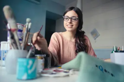 photo of female artist, reaching for paintbrush