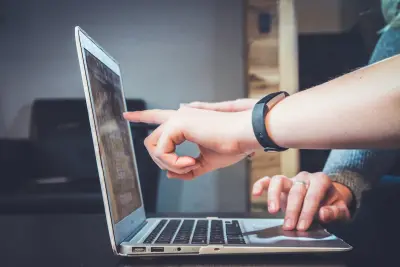 person using laptop, pointing at screen
