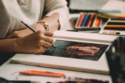 artist doing a pencil drawing at desk