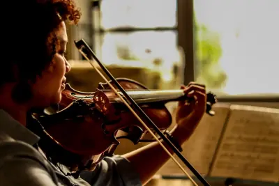 woman playing violin near window
